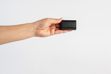 Black DSLR camera battery and hand on white background