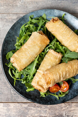 Crispy vegetables spring Rolls on wooden table. Top view