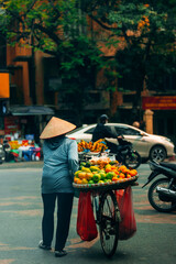 Woman walking in Hoi An with fruits to market, travel lifestyle of Vietnam