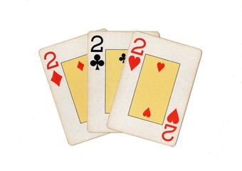 Vintage playing cards showing three of the same value on a white background.