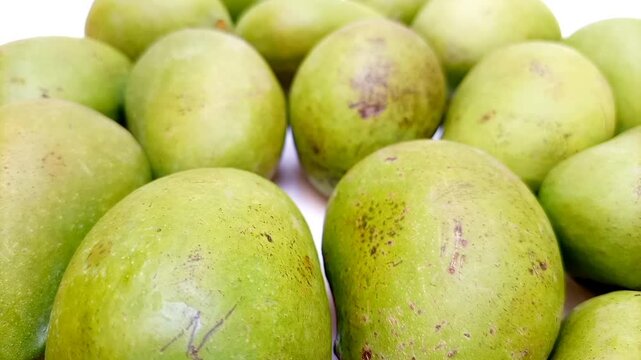 Fresh green mango fruits on white background rotating, tropical fruit, unripe mangoes for pickle