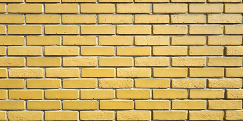 Obraz premium Uniform golden yellow brick wall displaying consistent coloring with standard rectangular masonry layout and visible mortar joints between bricks.