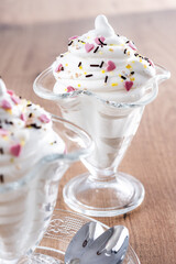 Whipped Cream Delight with Sprinkles on wooden table