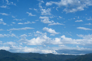 Obraz premium Blue sky with clouds and mountains in the background, nature background.