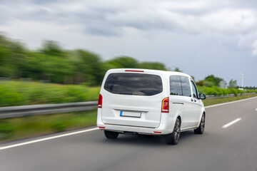 White minivan on highway. Car in motion. Road transportation.