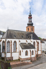 A large castle church with a steeple and a clock tower in Saarbrucken Germany