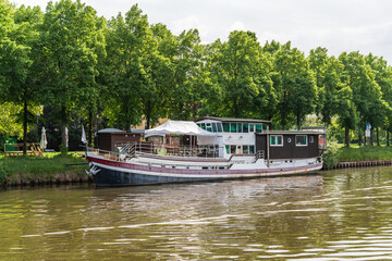 A boat is traveling down a Saar river near a Saarbrucken city in Germany