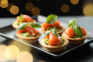 Tasty canapes on table, closeup. Bokeh effect