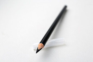Black eyebrow pencil on light background, closeup. Space for text