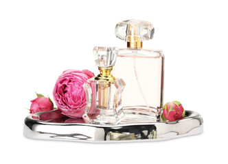 Different perfume bottles and roses isolated on white
