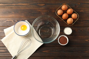 Making whipped cream. Bowl, whisk and ingredients on wooden table, flat lay