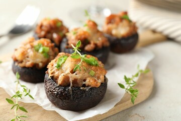 Tasty stuffed mushrooms served on light table, closeup