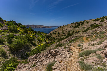 Low walls made of stone built by locals on the trail leading from Baska to Vela Luka beach,