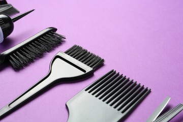 Different hairdresser's tools on violet background, closeup. Space for text