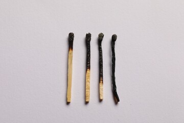 Burnt matches on grey background, flat lay