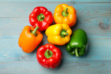 Fresh colorful bell peppers on blue wooden table, flat lay