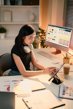 Designer woman working on branding project using digital tablet at modern creative office