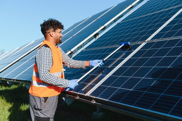 Engineer cleaning solar panels in a solar farm for renewable energy