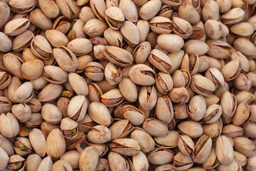 A bountiful overhead display of roasted pistachios in their shells, showcasing their natural, cracked appearance and appealing texture, ready for snacking