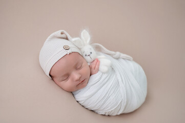 Peaceful newborn baby wrapped in white blanket
