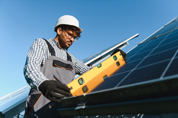 Engineer installing solar panels using level tool on sunny day