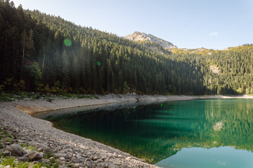 Beautiful natural landscape with a mountain lake and bright blue sky surrounded by mountains. Majestic mountains with a lake. Concept of tranquility and freedom.