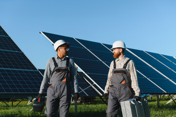 Engineers walking and talking in solar panel farm