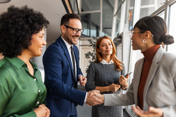 Professional Team Shaking Hands During Business Meeting in Modern Office Setting © Jelena