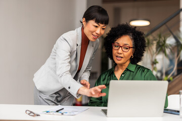 Obraz premium Professional Collaboration Between Two Women in Modern Office