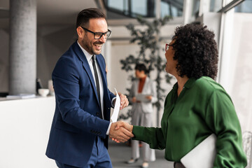 Business Professionals Shaking Hands in Modern Office Environment