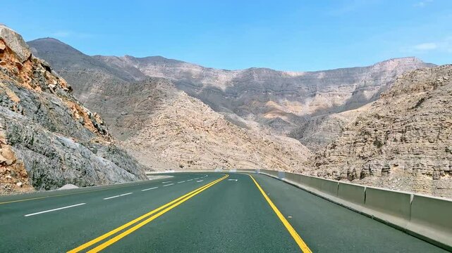 Mountain road in Ras Al Khaimah, United Arab Emirates, scenic view with rocky landscape and clear sky