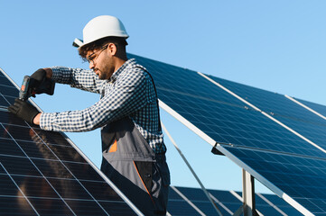 Skilled technician installing solar panels on clear day