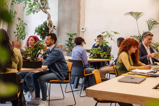 Coworkers collaborating and talking in modern green office