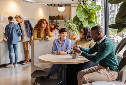 Diverse business team enjoying coffee break in modern office