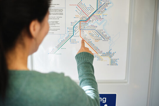 Young Asian woman pointing on the train map.