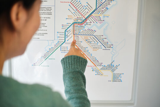 Young Asian woman pointing on the train map.