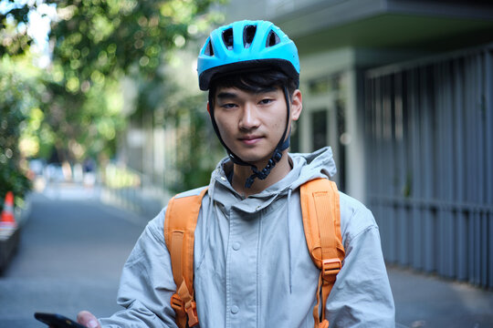 Portrait of young Asian delivery guy on the street