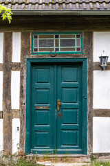 Wooden door with horseshoe. Green rustic entrance. Scandinavian country house.