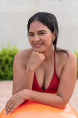 Latin woman relaxing after pilates workout with orange fitness ball