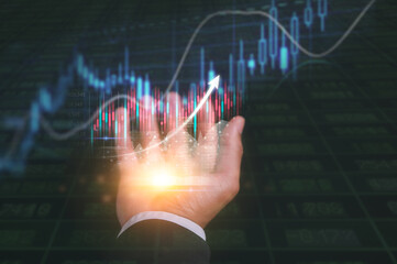 investment and finance concept, businessman holding virtual trading graph and blurred coins on hand, stock market, profits and business growth blurred stock market background