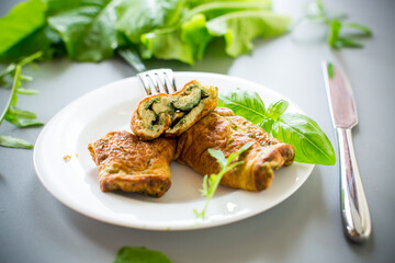 Delicious homemade omelette in the form of a roll with greens