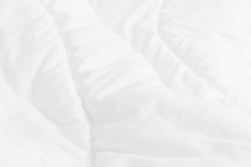 Close up top view of white bedding sheet and wrinkle messy blanket in bedroom after wake up in the morning.