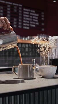 barista fills a cup with delicious cappuccino cup