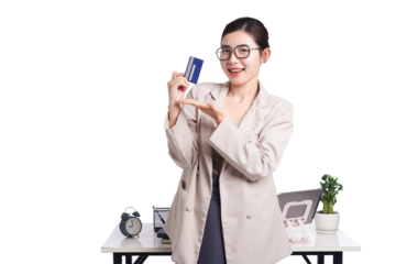 Asian businesswoman poses with bank card in hand, behind her is a table with lots of documents