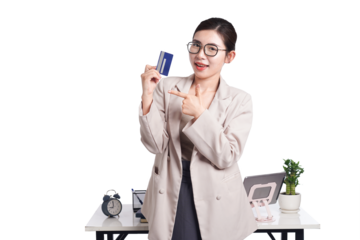 Asian businesswoman poses with bank card in hand, behind her is a table with lots of documents
