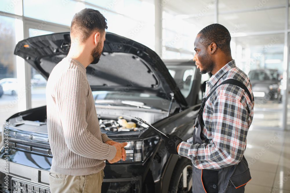 Poster man on the result of the work of a mechanic. the client evaluates the repair of the car by a mechani