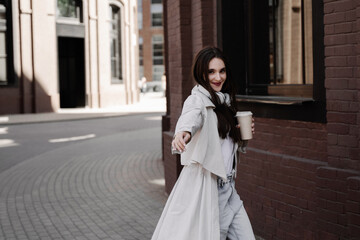 Fototapeta premium Stylish Woman Walking with Coffee in Urban Street