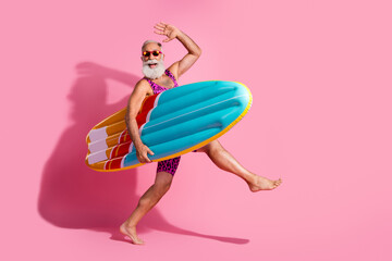 Plakat Photo of positive optimistic grandfather wear swimsuit summer vacation resort surfing isolated on pink color background