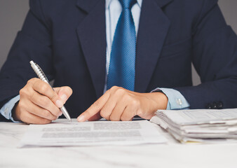 Businessman signing official document at desk symbolizing agreement, contract, or legal approval.