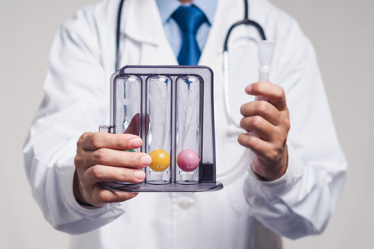 Doctor holding a respiratory incentive spirometer for lung exercise and pulmonary health training.